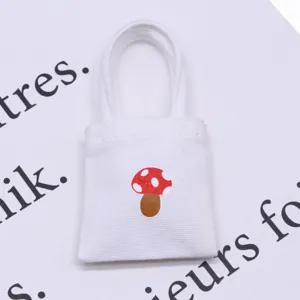 Miniature dollhouse canvas tote bag with cute red mushroom print for tiny scene display.