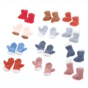 Mini knitted Christmas socks mittens detail shot, colorful craft hanging decorations.