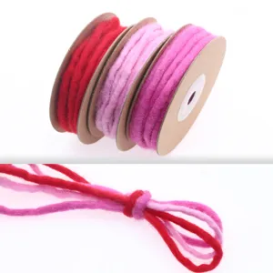 Detailed wool felt cord spools in vibrant red and pink colors for handmade DIY crafts.