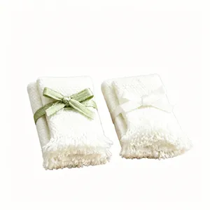 Miniature knitted towel detail with bow fringe, perfect dollhouse bathroom decor accessory.