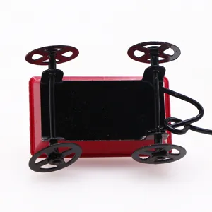 Detail shot of the miniature red metal wagon showing black undercarriage and wheels.