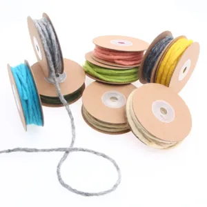 Detailed view of colorful handmade wool felt cords wound on cardboard spools for DIY crafts.