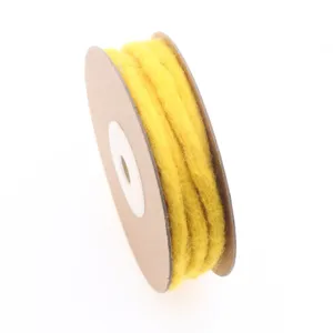 Nepalese handmade yellow wool felt rope on cardboard spool, ideal for DIY crafts and decor.