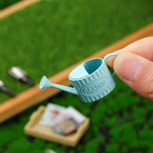 Close-up detail of miniature blue watering can for dollhouse garden landscape decor