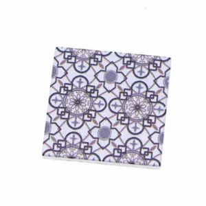 Close-up of miniature dollhouse wooden tile featuring retro geometric floral pattern.