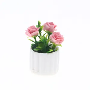 Gros plan de la plante en pot de roses artificielles miniatures pour maison de poupée.