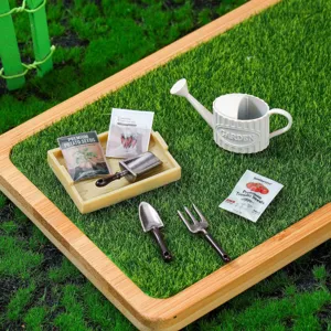 Dollhouse miniature gardening tool set detail featuring tiny watering can, shovel, and seed packs.