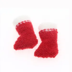 Close-up detail of mini red and white knitted Christmas boots decoration for festive tree hanging.