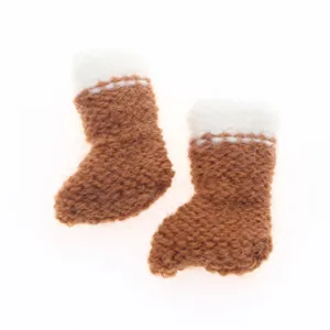 Miniature knitted brown boots detail, cute small wool shoes ornament close up display.