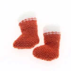 Mini knitted Christmas boots detail, cute red white wool sock pendant for holiday tree decor.