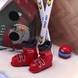 Miniatura botas de esquí rojas casa de muñecas accesorio escena nieve invierno primer plano.