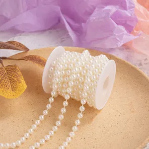 Detailed shot of white plastic pearl string on spool for DIY crafts, wedding and home decor.
