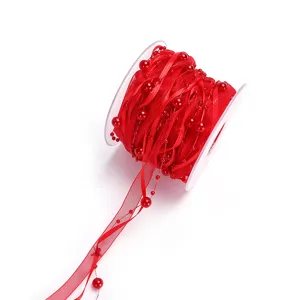 Red organza ribbon with pearl beads on spool, ideal for gift wrapping and DIY crafts decor.