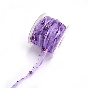 Purple organza ribbon roll with pearl beads detail for gift wrapping, crafts and floral decor.