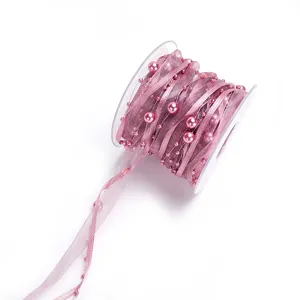 Pink organza ribbon roll with faux pearls detail for gift packaging and DIY crafts.