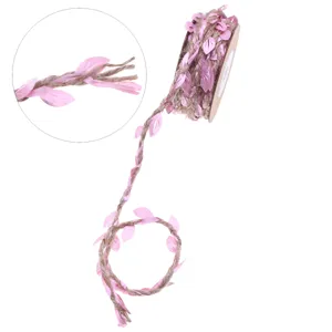 Close-up detail of braided jute twine with pink fabric leaves, perfect for craft and floral packaging.