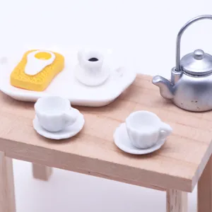 Vista detallada del juego de tazas y platos de cerámica en miniatura para decoración.