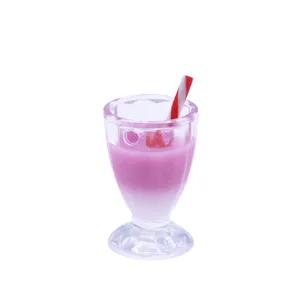Détail de gobelet en plastique pour maison de poupée avec milkshake rose et paille.