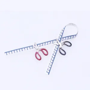 Miniature dollhouse sewing accessories set featuring tiny openable scissors and measuring tape.