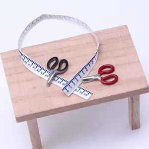 Dollhouse miniature sewing accessories set with tiny metal scissors and scale measuring tape.
