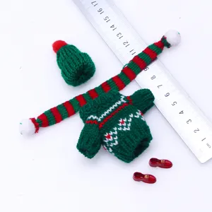 Mini doll knit sweater set detail view, green pullover, scarf, hat and tiny shoes.