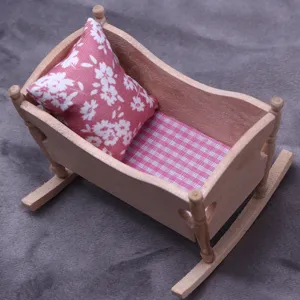 Miniatur Holz Puppenhaus Schaukelbett Detail mit rosa Blumenkissen und karierter Matratze.