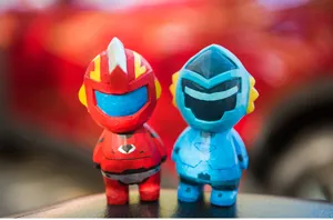 Détail de figurine de héros en bois sculpté, déco de bureau mecha rouge et bleu vif.