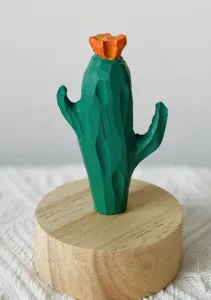 Handcrafted wooden cactus figurine with orange flower on round wooden base for home decor.