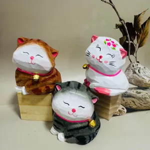 Handmade wooden cat figurine detail, cute desktop ornament with bell and floral pattern.
