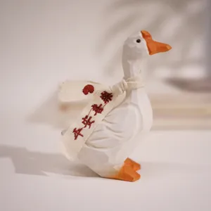 Close-up of handmade wooden duck figurine with fabric scarf and carved texture detail.