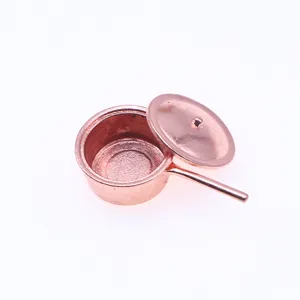 Gros plan détaillé d'une mini casserole en cuivre pour maison de poupée avec couvercle.