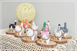Handmade wooden cat figurine detail showing cute painted design with bell and natural wood base.