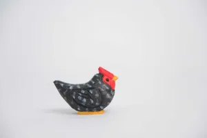 Détail de figurine de poulet en bois sculpté, joli animal tacheté pour déco maison.