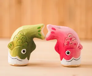 Gros plan détaillé d'ornements de poissons koi en bois sculpté de style artisanal.