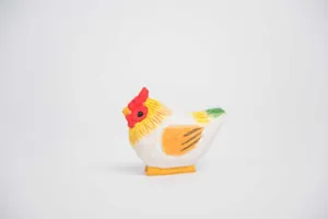 Détail en gros plan d'une figurine de poulet en bois peint à la main, décoration de bureau.