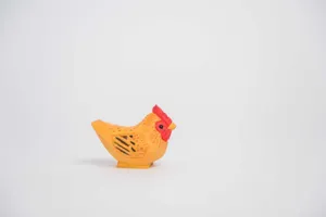 Détail de figurine de poule en bois sculpté avec texture et couleur pour déco bureau.