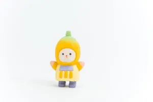 Close-up detail of the cute wooden banana figurine showing fine carving and hand-painted texture.