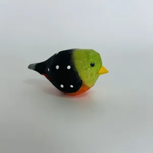 Hand carved wooden bird figurine detail close up view, colorful painted finish, smooth texture.