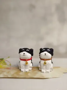 Wooden carved dog figurine detail view, handmade black and white puppy decor with bell.