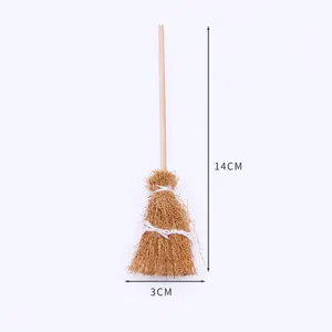 Miniature broom accessory detail shot, showing hand-woven texture and wooden handle structure.