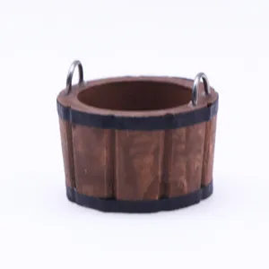 Detail shot of miniature wooden bucket model with metal handles for dollhouse props.