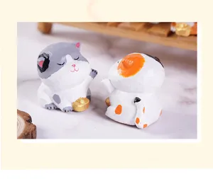 Cute wooden cat figurine ornament holding gold ingot, creative desktop decor detail view.