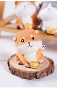 Close-up view of a cute wooden animal figurine holding a golden ingot on a tree slice base.