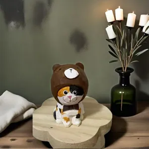 Handcrafted wooden carved kitten figurine wearing cute bear hat detail shot for home decor.