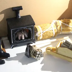 Miniature dollhouse winter scene set detail, featuring tiny wood cart and stove.