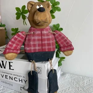 Jolie figurine de poupée ours en bois avec chemise à carreaux rouges et jambes pendantes