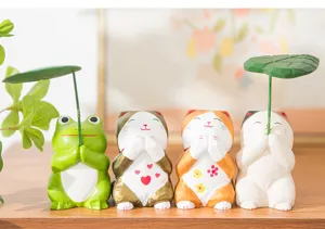 Close-up of cute wooden carved frog and lucky cat ornaments, perfect for cute desktop decor.