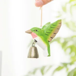 Handmade wooden hummingbird hanging ornament with metal bell for courtyard decor.
