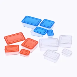 Detailed shot of miniature plastic bento boxes, colorful dollhouse food storage container props.
