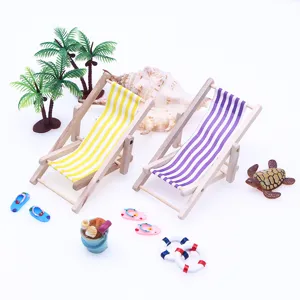Miniature wooden beach chair dollhouse detail shot, striped fabric miniature resort scene set.